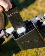 Scrubi golf club cleaner attached to a 3-wheel Clicgear, featuring durable bristles for effective club cleaning on the course with a golf ball cleaner cleaning a golf ball